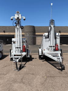 Two large white utility trailers parked in a parking lot.