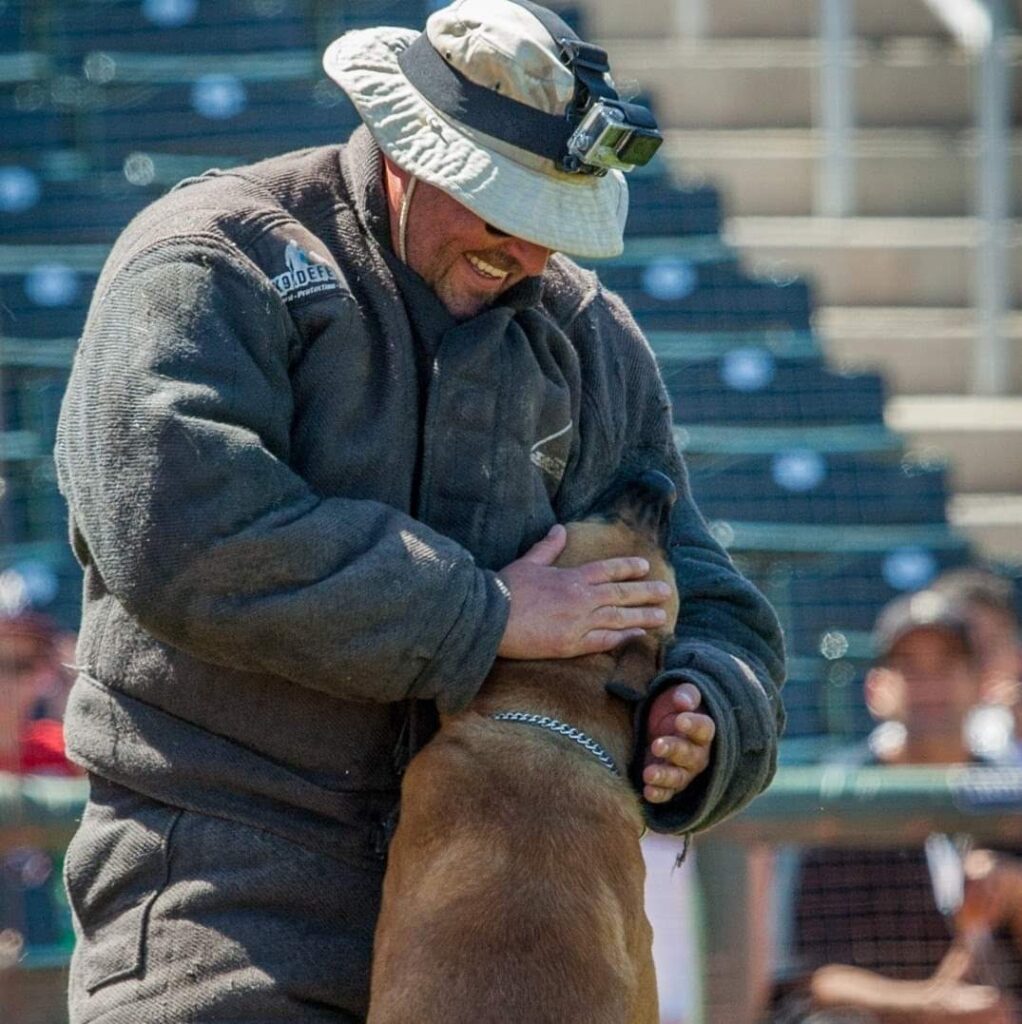 patrol-dogs2-1022x1024 A man in a hat and jacket holding a dog.